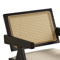 Eureka Ergonomic Black Mila dining chair close-up: handwoven rattan back, cream cushion, mid-century modern detail.