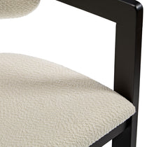 Eureka Ergonomic Close-up of ivory boucle fabric texture on Elle dining chair seat with matte black wood frame.