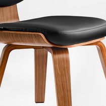 Eureka Ergonomic Belmar leather dining chair close-up: black stitched seat, bentwood frame, tapered legs.