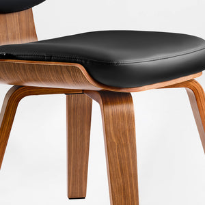 Eureka Ergonomic Belmar leather dining chair close-up: black stitched seat, bentwood frame, tapered legs.