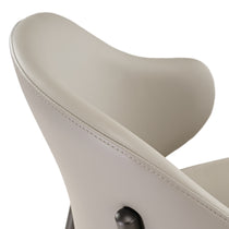 Noble Gray Upholstered Dining Chair Detail With Elegant Stitching and Curved Backrest.