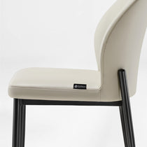 Off-White Leather Dining Chair Profile View With Black Metal Legs. Minimalist Modern Design.