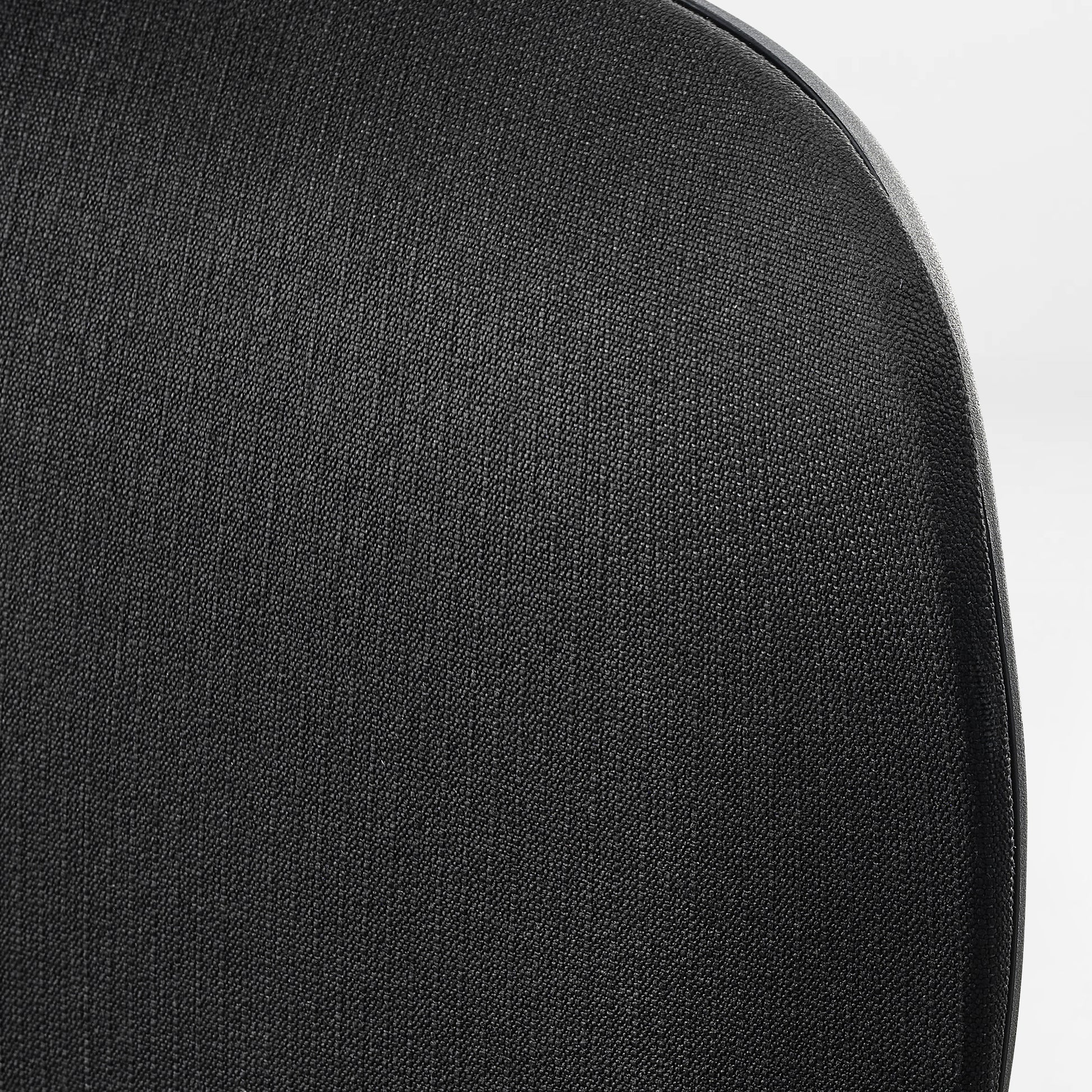 Close-up of a black chair with a textured surface.green, fabric