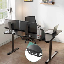 Black L-Shaped Gaming Desk With Cable Management, Three Monitors, and Laptop.