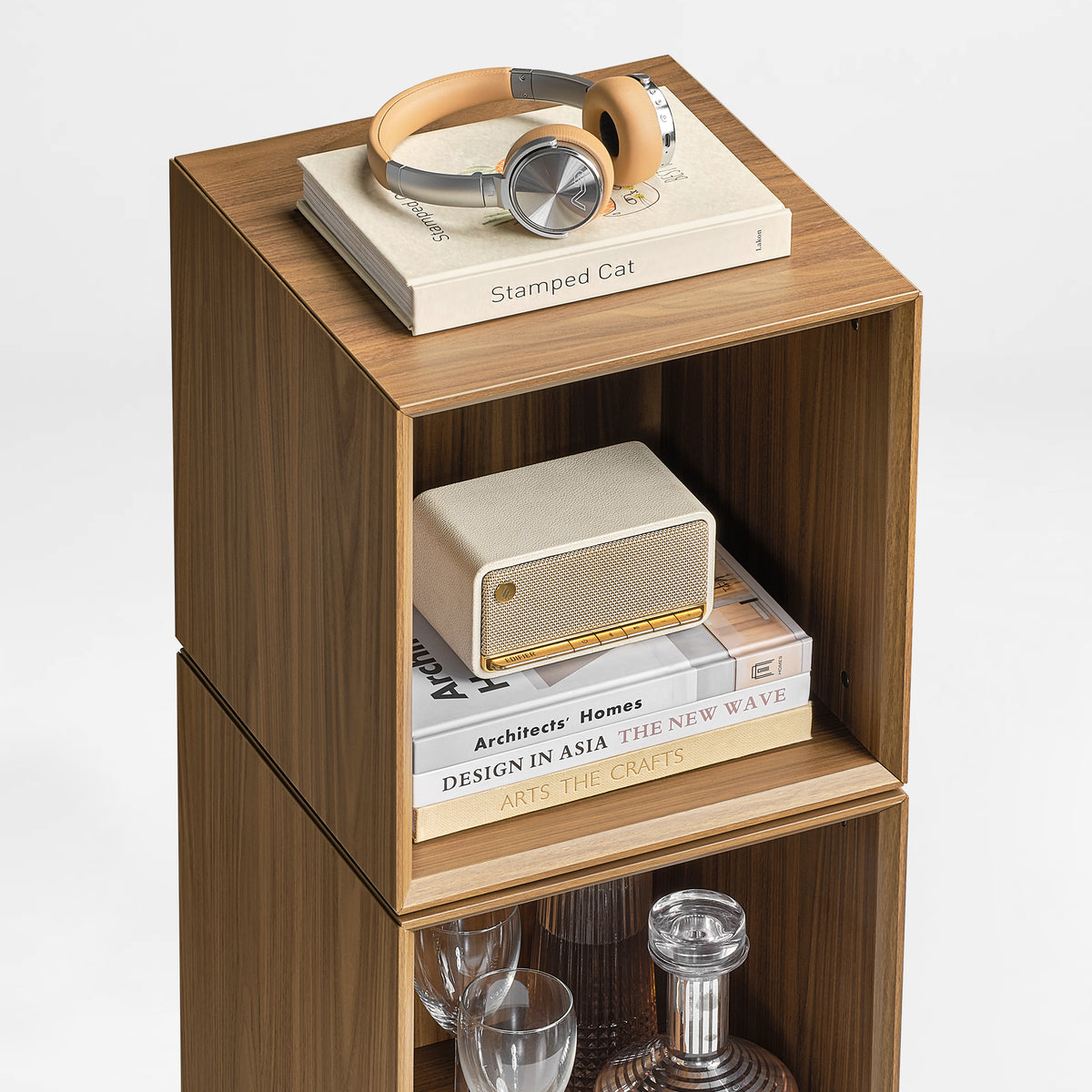 Eureka Ergonomic Cubo walnut cube styled with over-ear headphones, a book and a portable speaker on top