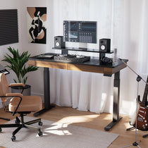 Ergonomic Home Studio Setup With Standing Desk, Wood Finish and Black Top, Monitor, Microphone and Guitar.