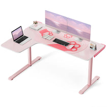 Pink L-Shaped Gaming Desk With Two Monitors, Laptop, Paw Print Mousepad, and Decor.