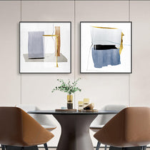 Set of 2 Abstract Wall Art Prints With Gold and Blue Accents, Framed and Displayed Above a Dining Table.