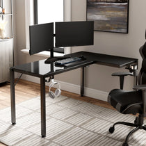 Black L-Shaped Glass Gaming Desk With Dual Monitors, Keyboard, Headphones, and Gaming Chair.
