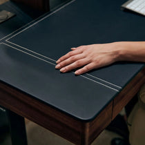 Faux Saddle Leather Desk Detail With Hand, Highlighting the Surface Texture and Stitching of the Standing Desk.